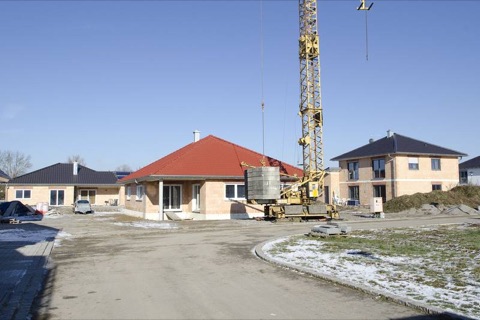 Neubaugebiet mit mehreren Rohbauten und gelbem Turmdrehkran